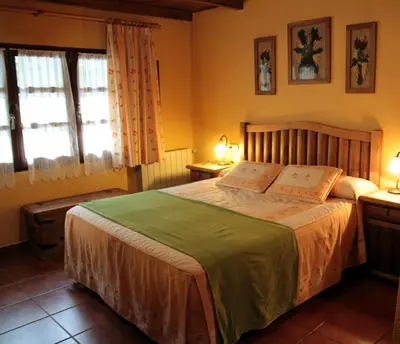 a bedroom with a large bed and two windows at Tixileiro in Sisterna