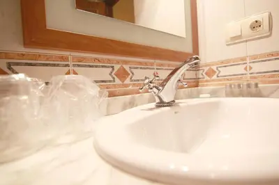 a white sink in a bathroom with a mirror at Tixileiro in Sisterna