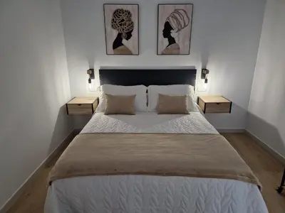 a bedroom with a large bed with two night stands at Apartamentos Pasiño in Portomarin