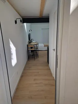 a hallway leading to a room with a table at Apartamentos Pasiño in Portomarin
