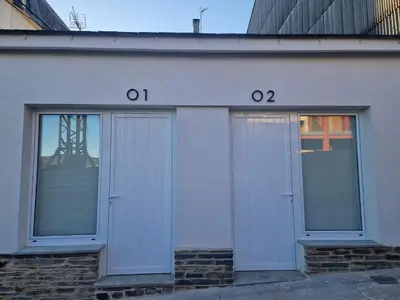 two doors on the side of a white building at Apartamentos Pasiño in Portomarin