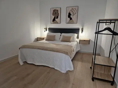 a bedroom with a bed and two pictures on the wall at Apartamentos Pasiño in Portomarin