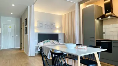 a kitchen and dining room with a table and a bed at The Cliffs A Ribeira - Pampillosa in Foz