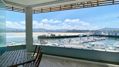 a balcony with a view of a marina with boats at The Cliffs A Ribeira - Rapadoira in Foz
