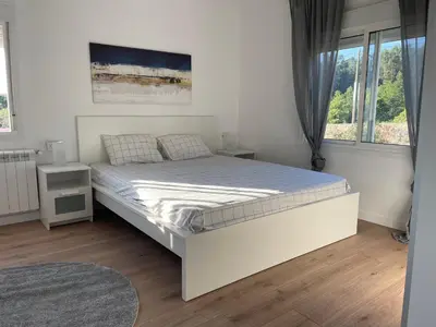 a white bedroom with a bed and a window at Casa vanguardista en el campo cerca de Santiago in Pontevedra