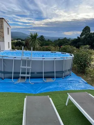 a large pool on a blue tarp with a table and a table at Casa vanguardista en el campo cerca de Santiago in Pontevedra