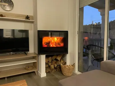 a fireplace in a living room with a tv at Casa vanguardista en el campo cerca de Santiago in Pontevedra