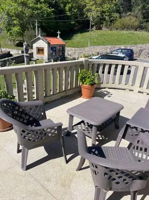 a patio with a table and chairs and a wooden fence at Casa do Ferreiriño in Chacente