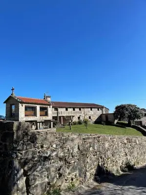a stone wall in front of a house at Casa do Ferreiriño in Chacente