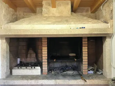 a brick oven with a stove in it at Casa do Ferreiriño in Chacente
