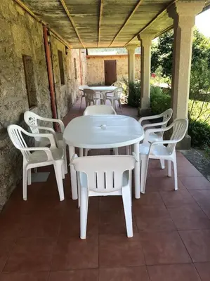 a white table and chairs on a patio at Casa do Ferreiriño in Chacente