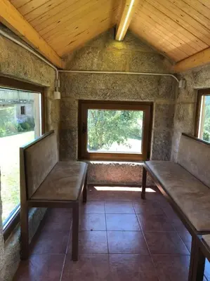 a room with two benches and a window at Casa do Ferreiriño in Chacente