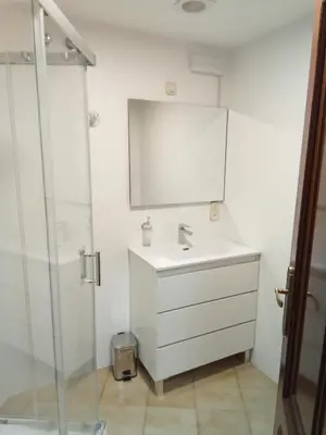a white bathroom with a sink and a mirror at Pensión La Plaza in Betanzos