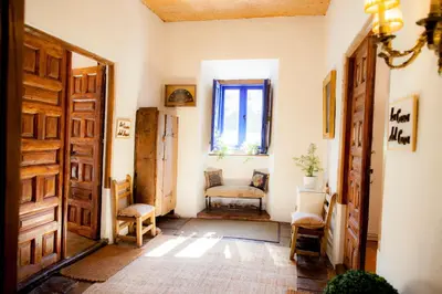 a room with a door and a chair and a window at Arzipreste I Casa del Cura in León
