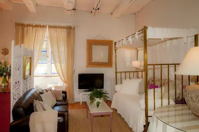 a bedroom with a canopy bed and a living room at Arzipreste I Casa del Cura in León
