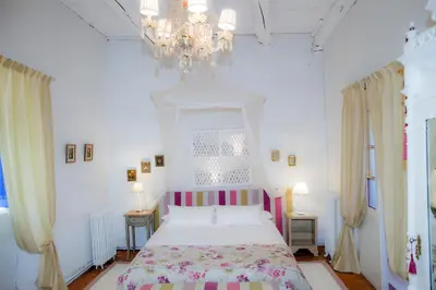 a bedroom with a bed and a chandelier at Arzipreste I Casa del Cura in León