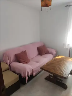 a pink couch in a living room with a coffee table at Casa la Camila in Tapia de Casariego
