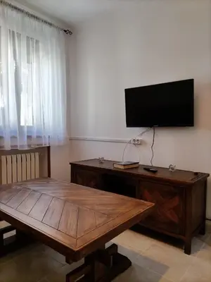 a living room with a wooden table and a flat screen tv at Casa la Camila in Tapia de Casariego