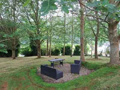 a picnic table and two chairs in a park at Casa Doñano in Ribadeo
