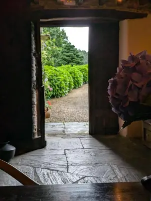an open door with a view of a garden at Casa Doñano in Ribadeo