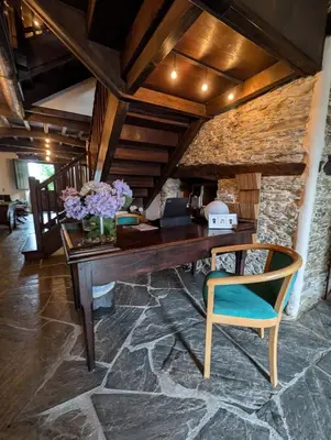 a wooden desk with a vase of flowers on it at Casa Doñano in Ribadeo