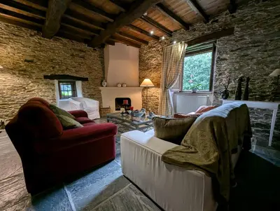 a living room with two couches and a brick wall at Casa Doñano in Ribadeo