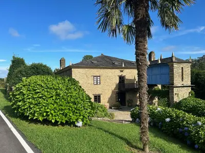 a house with a palm tree in front of it at Casa Doñano in Ribadeo