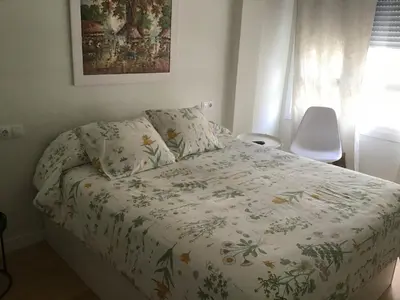 a bedroom with a bed with a flowered comforter at Mi lugar de vacaciones in Miño
