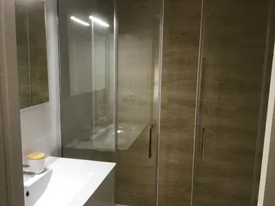 a shower with a glass door next to a sink at Mi lugar de vacaciones in Miño