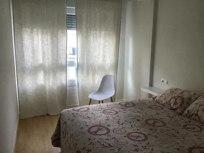 a bedroom with a bed and a chair and a window at Mi lugar de vacaciones in Miño