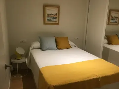 a small bedroom with two beds with yellow sheets at Mi lugar de vacaciones in Miño