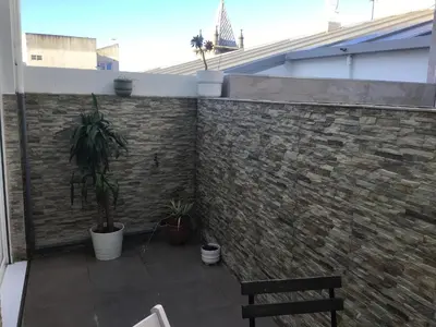 a brick wall with a bench and a plant at Mi lugar de vacaciones in Miño