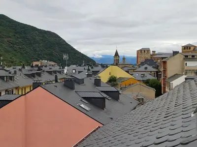 a view of roofs of a city with mountains in the background at La Tebaida in Ponferrada