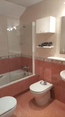 a bathroom with a toilet and a tub and a sink at La Tebaida in Ponferrada