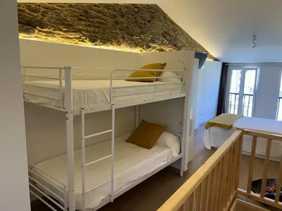 a bedroom with two bunk beds in a room at A Casiña do Rey Casita junto a la playa de Cabañas in Cabañas