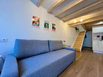 a blue couch in a living room with a staircase at A Casiña do Rey Casita junto a la playa de Cabañas in Cabañas
