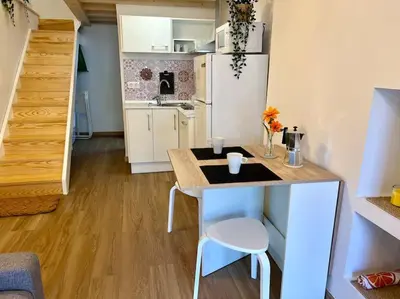 a small kitchen with a table in a small apartment at A Casiña do Rey Casita junto a la playa de Cabañas in Cabañas
