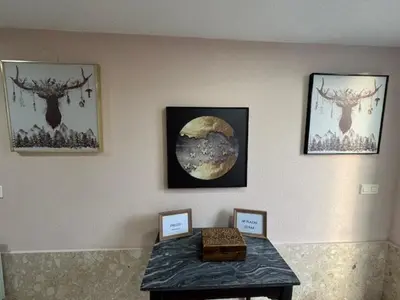 a room with paintings on the wall with a table at Pensión Portus Marini in Portomarin