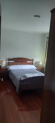 a bedroom with two beds and a window at Pensión Portus Marini in Portomarin