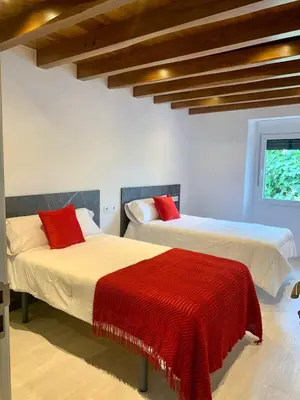 two beds with red pillows in a room at Amencer en Llas in Foz