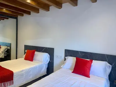 two beds in a room with red pillows on them at Amencer en Llas in Foz
