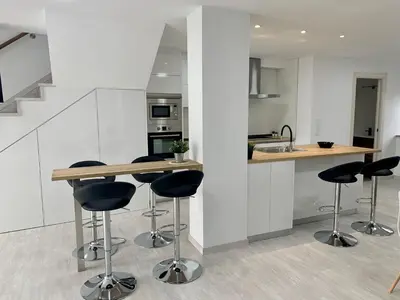 a kitchen with a counter and stools in a room at Amencer en Llas in Foz