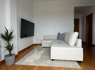 a white living room with a white couch and a tv at Apartamento Playa las catedrales in Foro