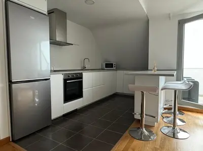 a kitchen with white cabinets and stainless steel appliances at Apartamento Playa las catedrales in Foro
