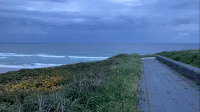 a walkway next to the ocean on a beach at Apartamento Playa las catedrales in Foro