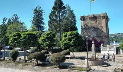 a park with bushes and a castle in the background at Adiva Suite in Puentedeume