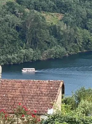 a boat in the water near a river at Casa do Feligrés e da Alsira in Nogueira