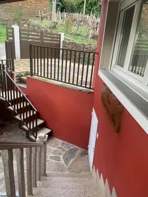 a set of stairs with a red wall and a window at Casa do Feligrés e da Alsira in Nogueira