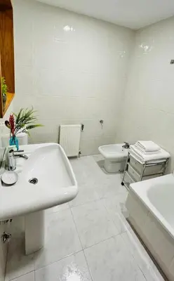 a white bathroom with a sink and a toilet at Duplex Olas de Ribadeo in Ribadeo