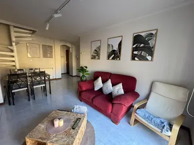 a living room with a red couch and a table at Duplex Olas de Ribadeo in Ribadeo